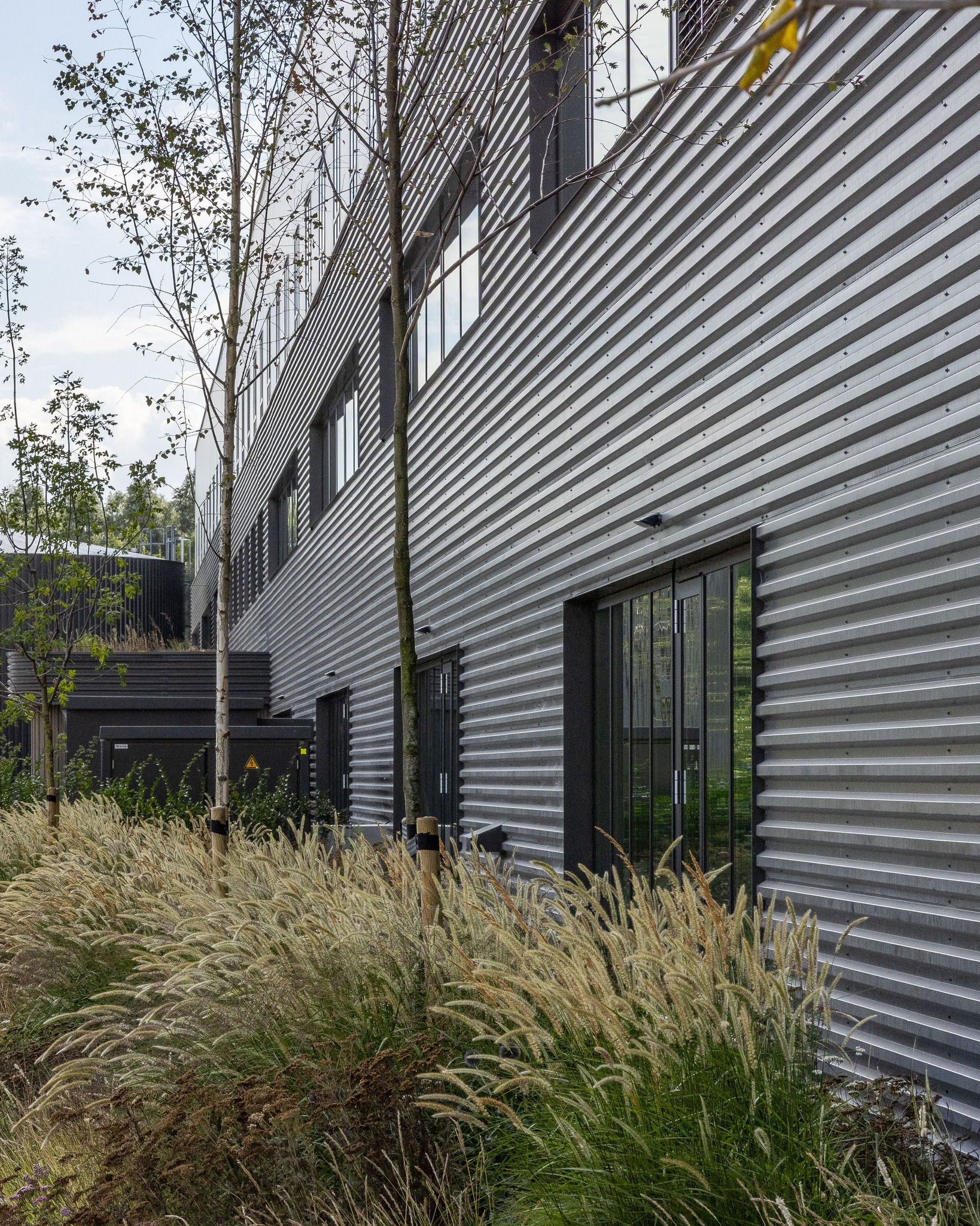 Seed Connect Centre Rijk Zwaan

Volgens architect-partner Simon Hanemaaijer begint gezondheid bij daglicht en uitzicht. “We weten inmiddels goed hoe dat werkt in kantoren, maar in een enorme fabriekshal is dat een veel grotere uitdaging.” Het gevelontwerp is daarom parametrisch geoptimaliseerd. Er is zorgvuldig gezocht naar de juiste balans tussen maximale daglichttoetreding en uitzicht op het omliggende groen en het beperken van warmtelast en bouwkosten.

#RoosRosArchitecten #RoosRos #gezond #toekomstgericht #RijkZwaan #SeedConnectCentre #MFO